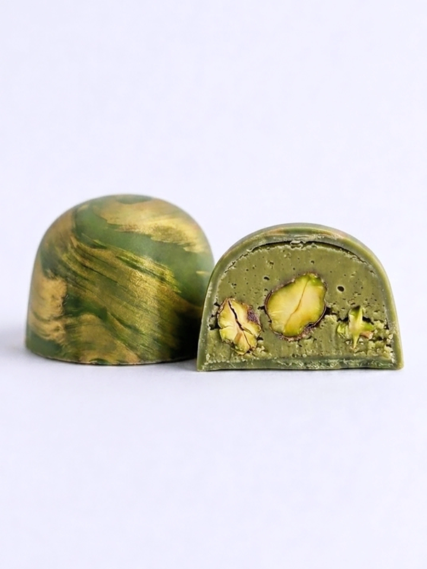 Pistachio dome bonbon with whole pistachio inside, cross-section